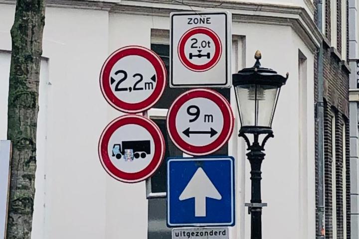 Een paal met vijf verschillende verkeersborden