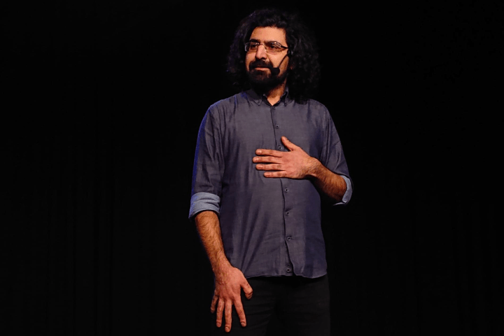 Stand-up comedian Hermes Ahmadi op het podium